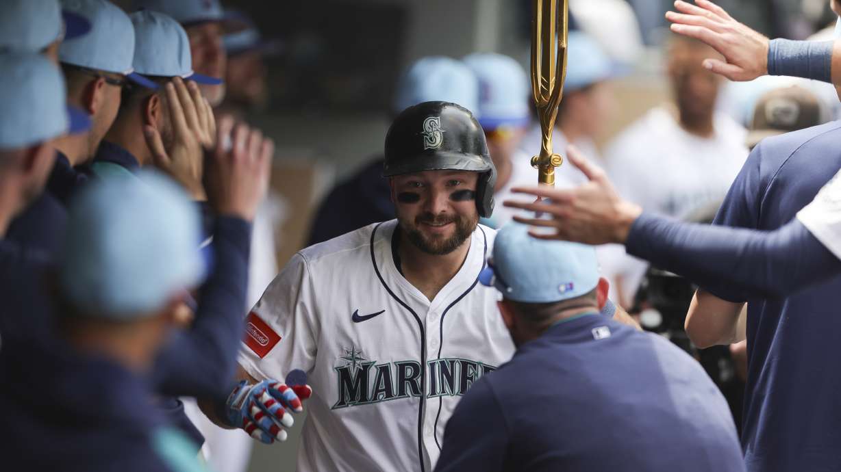 Seattle Mariners designated hitter Cal Raleigh celebrates in the dugout after hitting a solo home run during the sixth inning of a baseball game against the Pittsburgh Pirates, Friday, July 4, 2025, in Seattle.