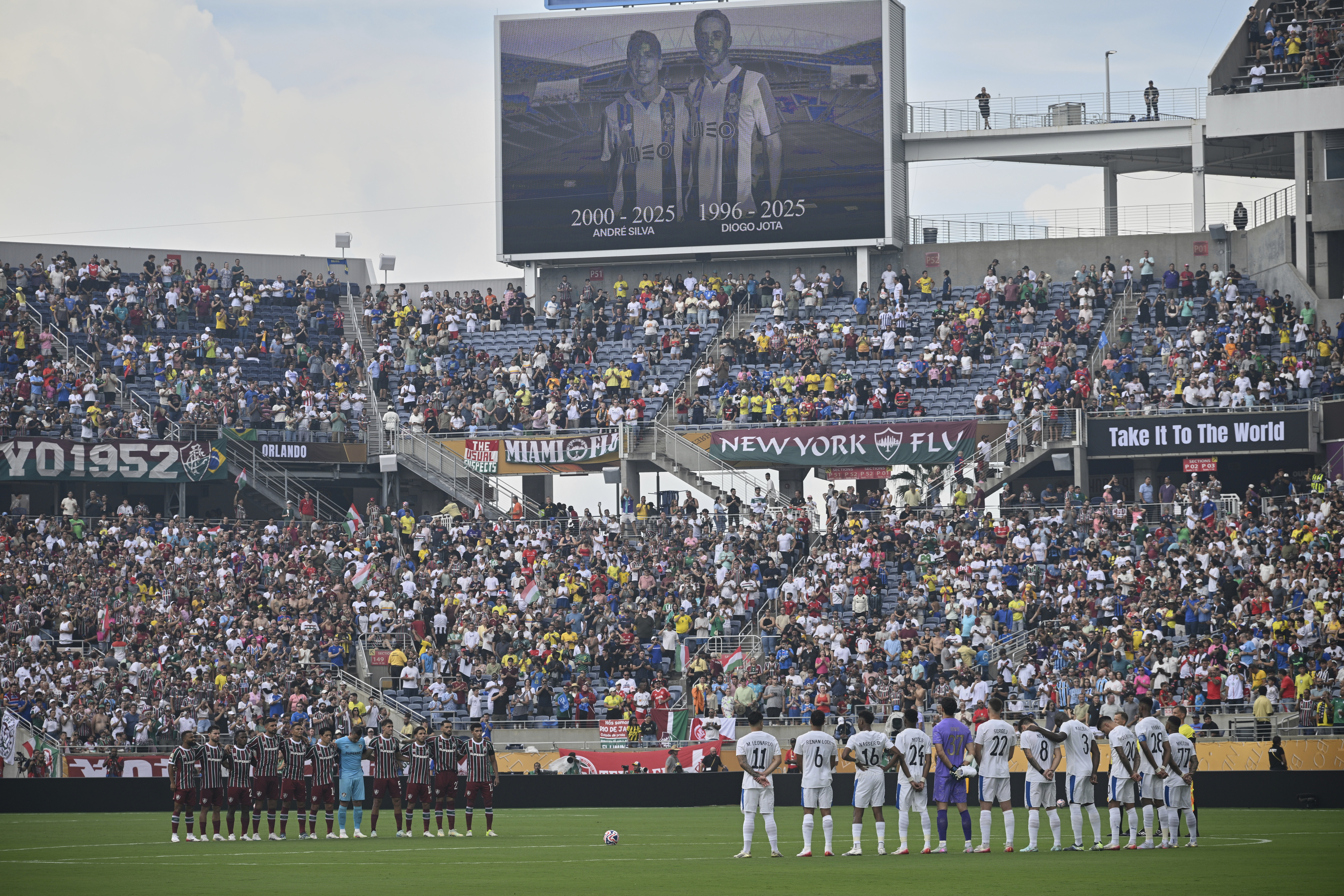 Players stand during a minute of silence for two soccer players who were killed in a car crash, Diogo Jota and his brother Andre Silva, before the Club World Cup quarterfinal soccer match between Fluminense and Al Hilal in Orlando, Fla., Friday, July 4, 2025. 