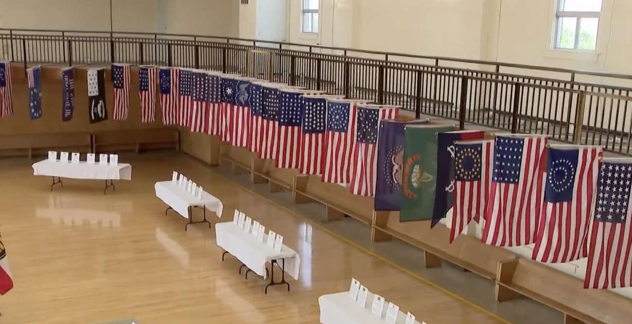 A display of 78 different flags fills the Elite Hall in Hyrum, with early colonial militia flags on one side and the different stars and stripes designs on the other.