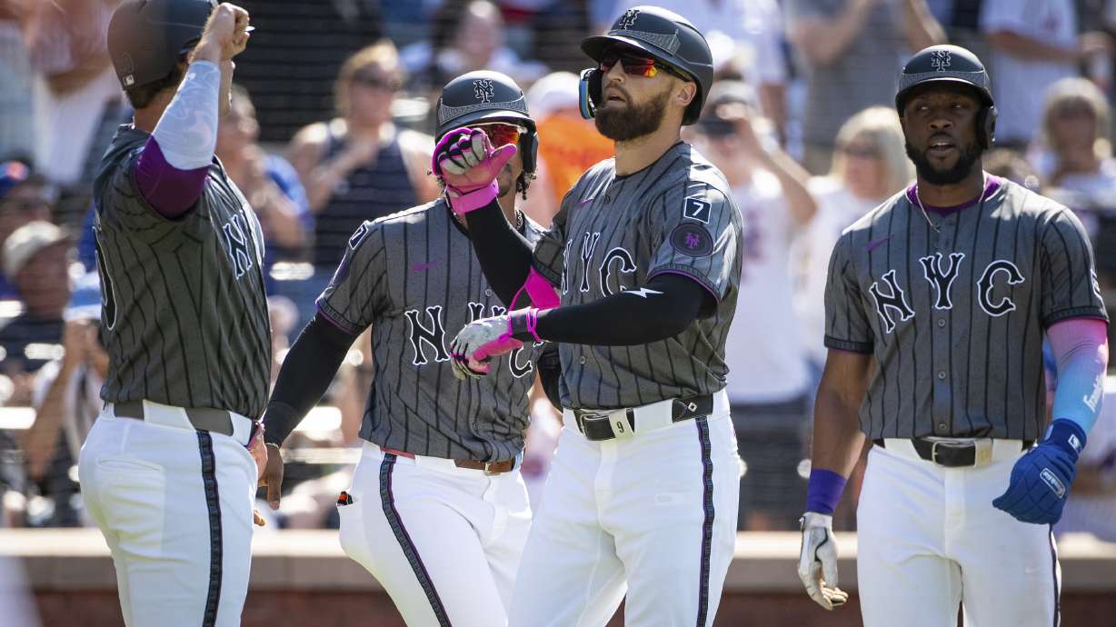 New York Mets' Brandon Nimmo celebrates his grand slam with the scorers, Pete Alonso, Fransisco Lindor and Starling Marie, during the first inning of a baseball game against the New York Yankees, Saturday, July 5, 2025, in New York.