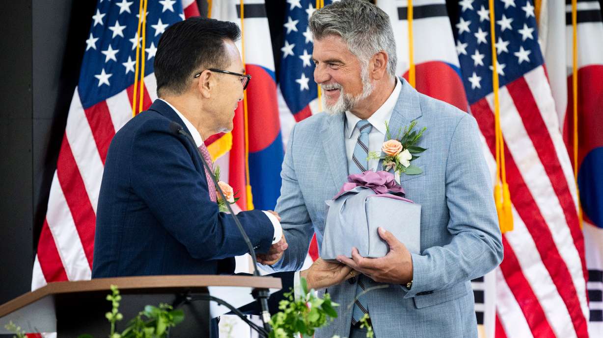 Jae Ho Lee, mayor of Incheon, Yeonsu-gu, South Korea, shakes hands with Mike Weichers, mayor of Cottonwood Heights, after Weichers received a gift during a sister city welcome and celebration dinner Saturday.
