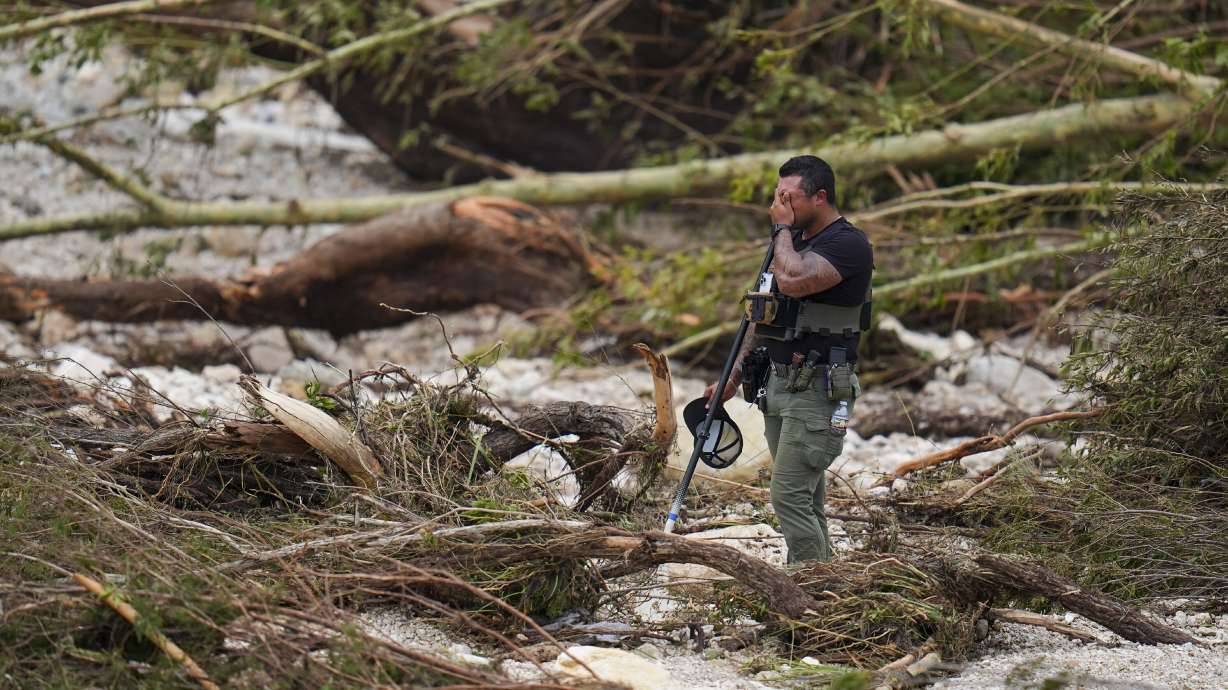 A Sheriff's deputy at the banks of the Guadalupe River after a flash flood swept through the area Saturday in Hunt, Texas.
