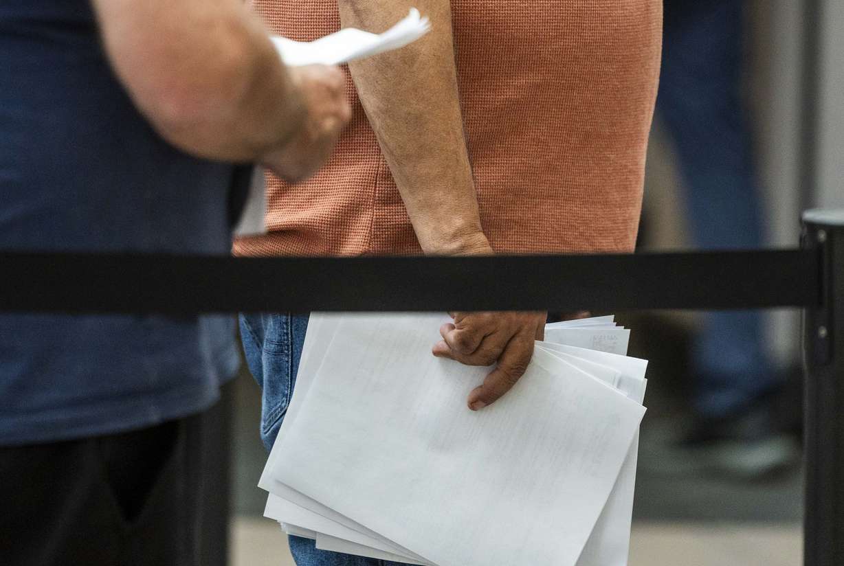 People wait in line with their paperwork at the Utah Department of Workforce Services in Taylorsville on Thursday. A new Deseret News poll found Utah voters are mixed on local versus national fiscal health.