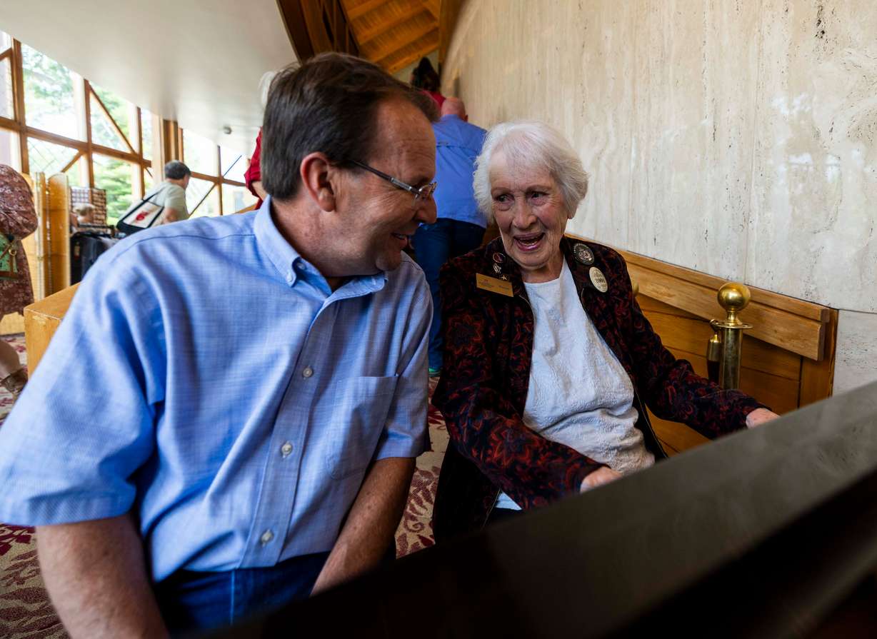 Doreen Woolley talks with Michael Bahr, the executive managing director of the Utah Shakespeare Festival, while continuing to play the piano for arriving audience members in the lobby of the Randall L. Jones Theatre before a theatrical performance in Cedar City on June 20.