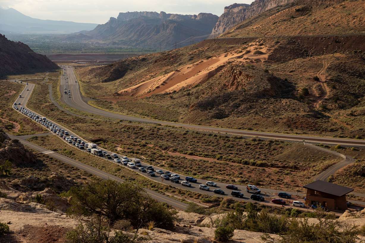 The entrance road to Arches National Park outside Moab begins to back up with visitors, Sept. 19, 2021.