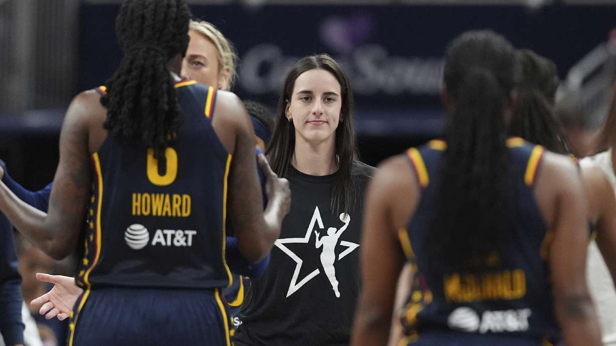 Indiana Fever's Caitlin Clark, middle greets teammates during the first half of a WNBA basketball game against the Las Vegas Aces, Thursday, July 3, 2025, in Indianapolis.