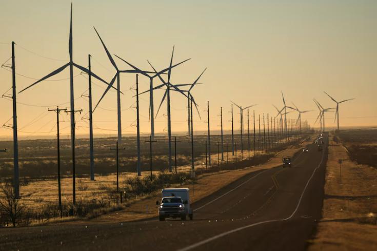 Wind turbines are visible along Route 176 as vehicles travel eastbound Feb. 24, in Andrews, Texas.