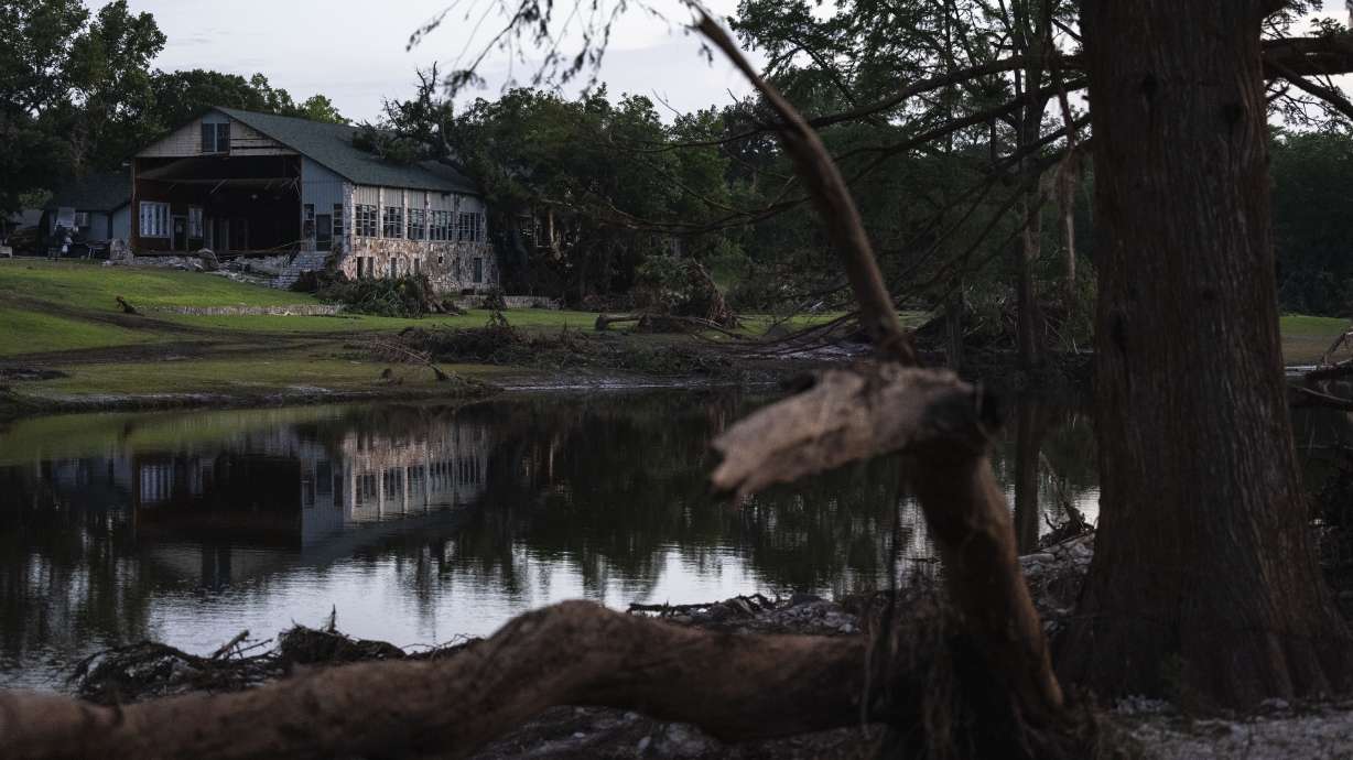 Camp Mystic is reflected in water after a flash flood swept through the area Monday, in Hunt, Texas.