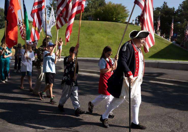 Liberty's Light Day Camp For Young Patriots campers follow Doug McGregor, a member of the Utah Society Sons of the American Revolution, after a flag-raising ceremony in Murray City Park, June 27.