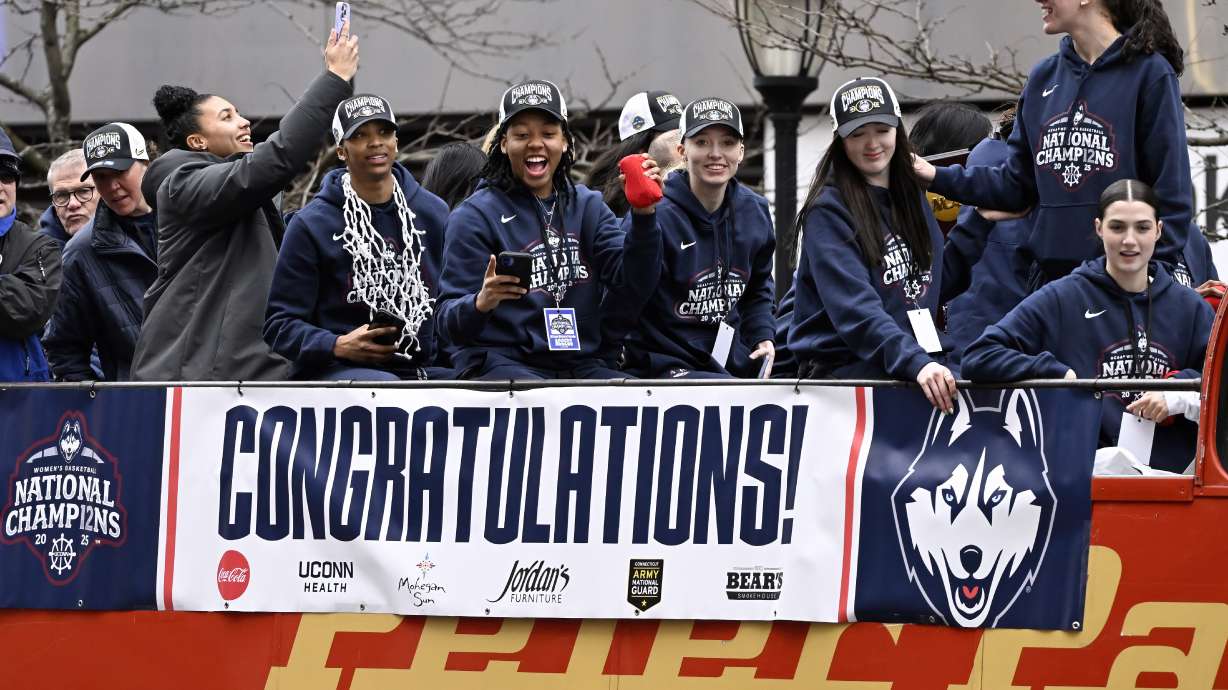 FILE - Members of the UConn women's basketball team celebrate from a bus during a parade celebrating the Huskies' NCAA women's college basketball championship, April 13, 2025, in Hartford, Conn.