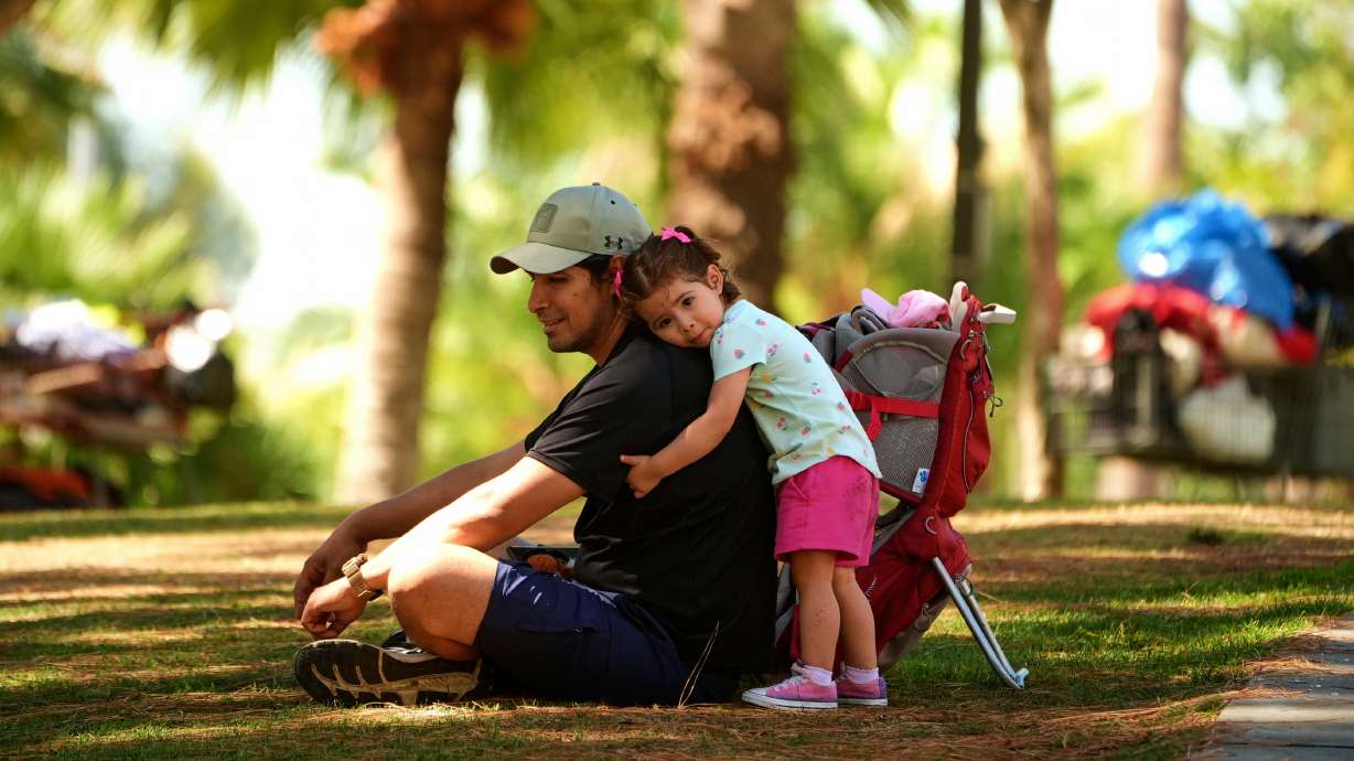Miguel Hernandez is hugged by his 1-year-old daughter Sayreli at MacArthur Park, July 8, in Los Angeles. A bipartisan group of lawmakers is calling for the Trump administration to provide protections for some undocumented immigrants.