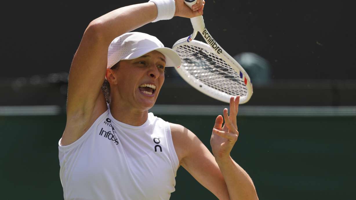Iga Swiatek of Poland plays a return to Liudmilla Samsonova of Russia during the women's singles quarter final match at the Wimbledon Tennis Championships in London, Wednesday, July 9, 2025.