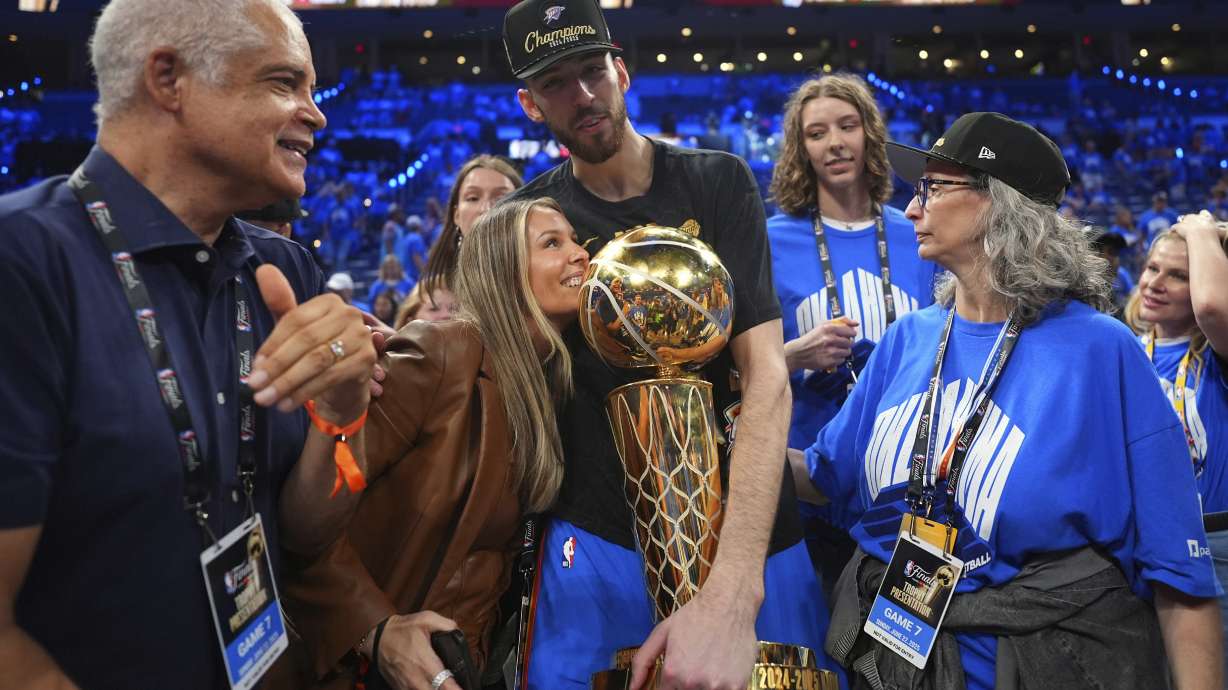 Oklahoma City Thunder forward Chet Holmgren, center, holds the Larry O'Brien Championship Trophy as he celebrates with his team after winning the NBA basketball championship with a Game 7 victory against the Indiana Pacers Sunday, June 22, 2025, in Oklahoma City.