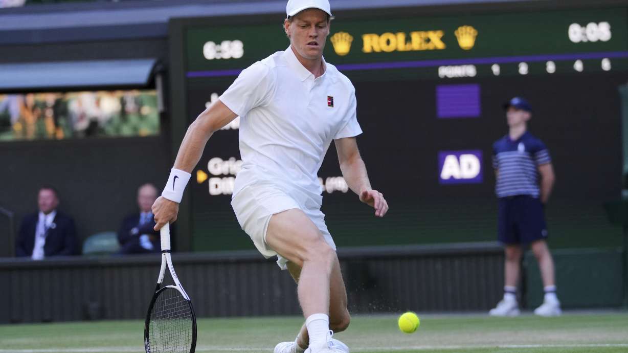 Italy's Jannik Sinner slides in to kick a ball he could not retrieve against Bulgaria's Grigor Dimitrov during a fourth round men's singles match at the Wimbledon Tennis Championships in London, Monday, July 7, 2025.
