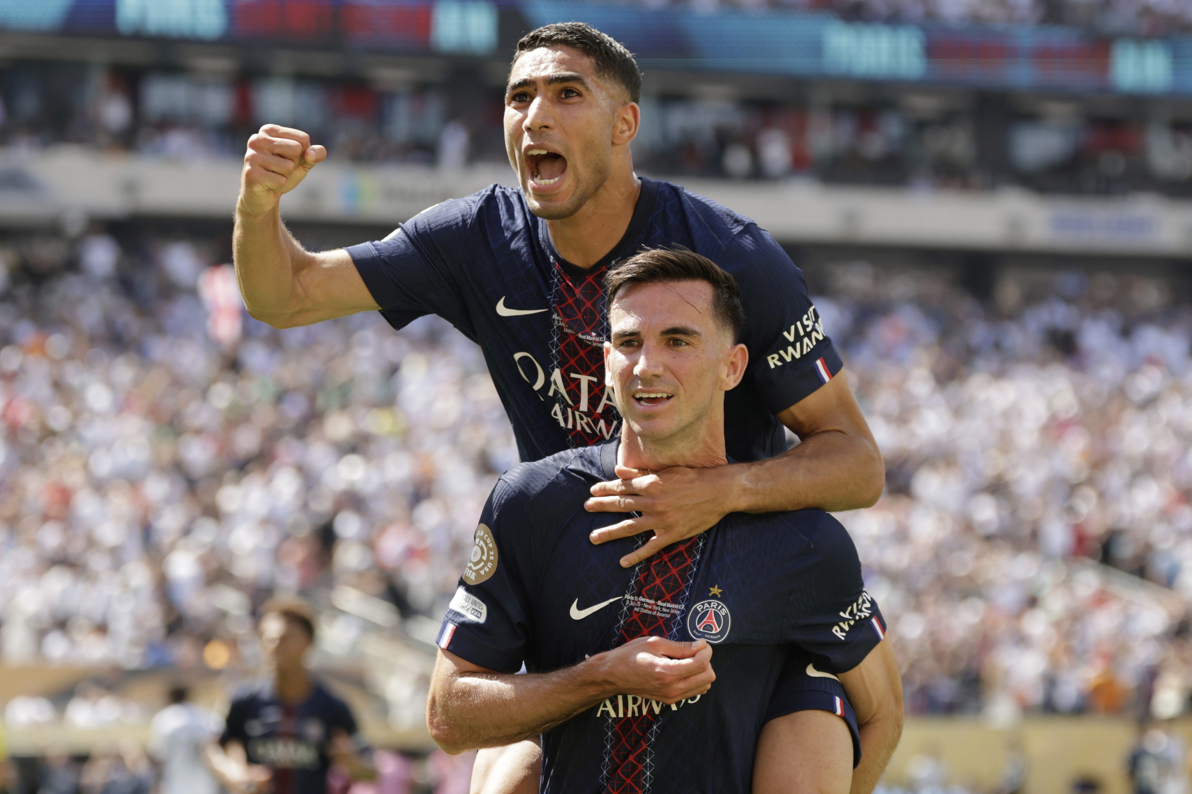 Paris Saint-Germain's Fabian Ruiz, bottom, celebrates with team mate Achraf Hakimi after scoring his side's third goal during the Club World Cup semifinal soccer match between PSG and Real Madrid in East Rutherford, N.J., Wednesday, July 9, 2025.