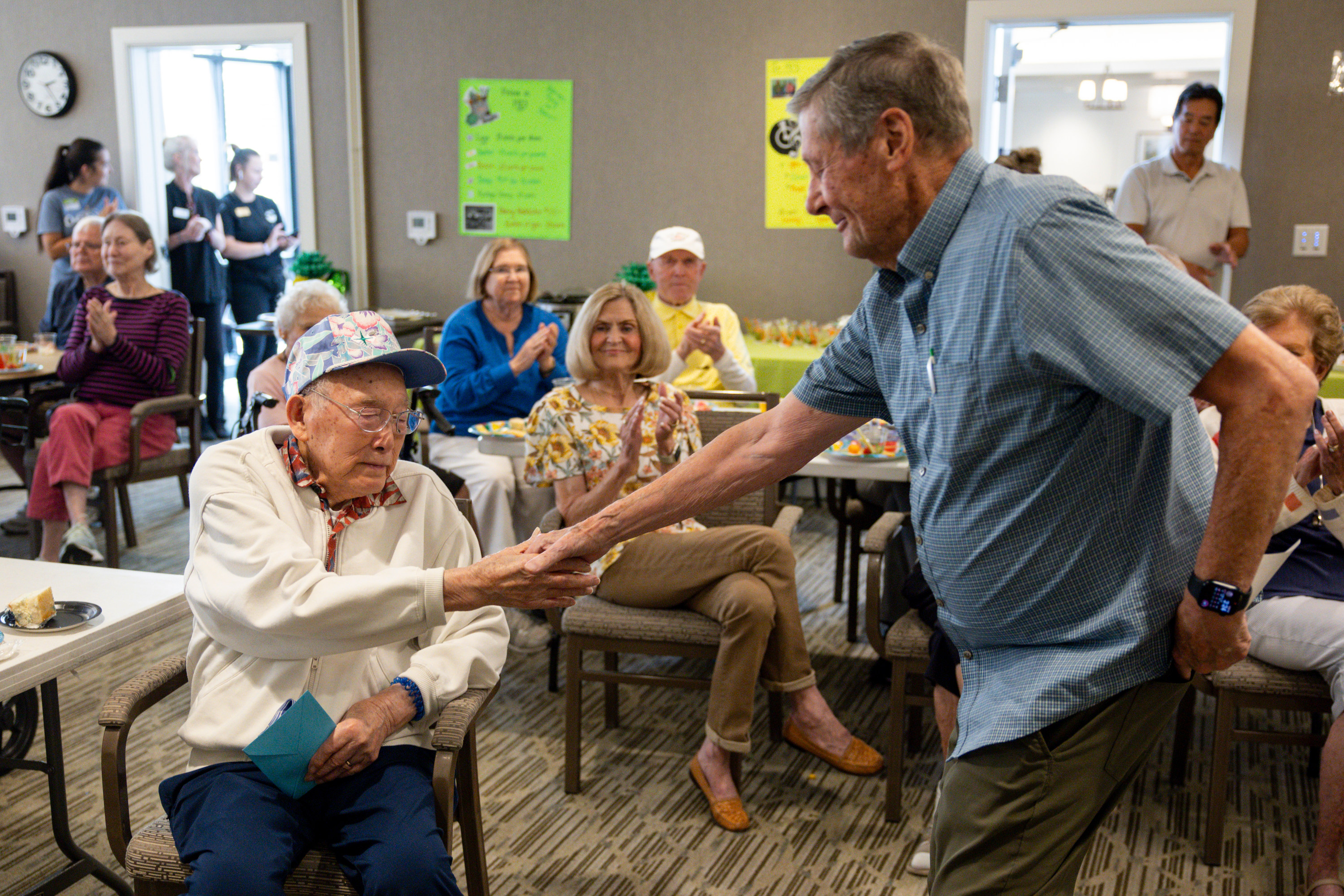 Warren Fong and Clyde Seely share a moment during Warren’s 102nd birthday party at the Legacy House of Park Lane in Farmington on Wednesday.