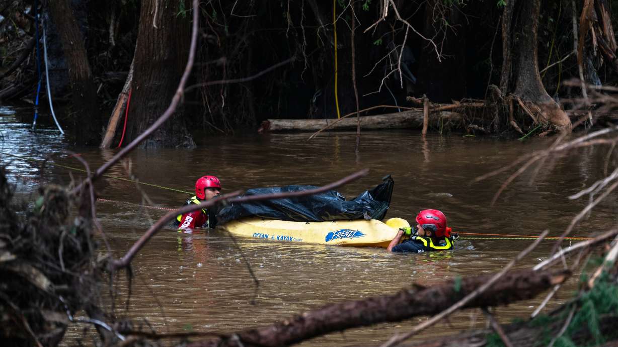 Firefighters from Ciudad Acuña, Mexico, transport a recovered body on the flooded Guadalupe River days after a flash flood swept through the area, Monday, in Ingram, Texas.