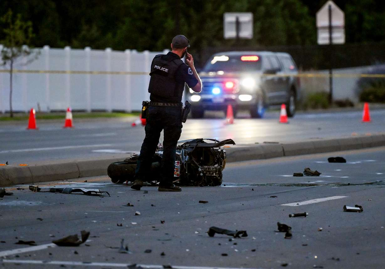 An officer talks on his phone as he stands over one of the motorcycles as they investigate a fatal accident at 1300 West and 11400 South in South Jordan on Wednesday.