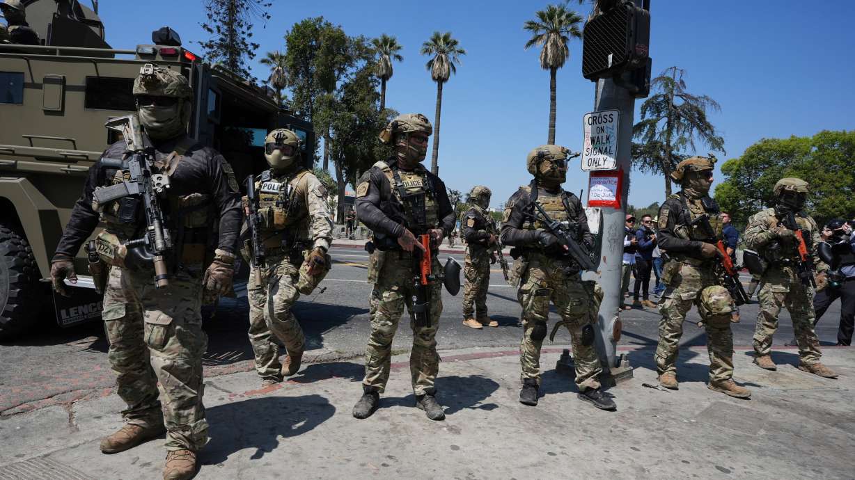 Federal agents stage at MacArthur Park Monday in Los Angeles. President Donald Trump's promise of mass deportations is being felt throughout the American West.