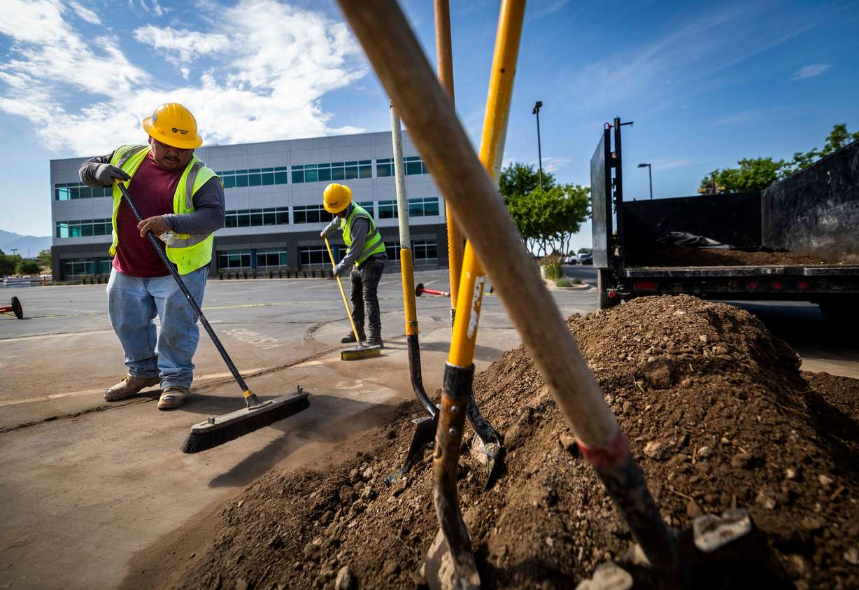 Eufemio Aguayo and Idelfonso Cabrera, both H-2B visa workers from Mexico, both clean up a work site for Stratton Landscape Group in Lindon on July 1. Utah immigrants make up 20% of the construction workforce.