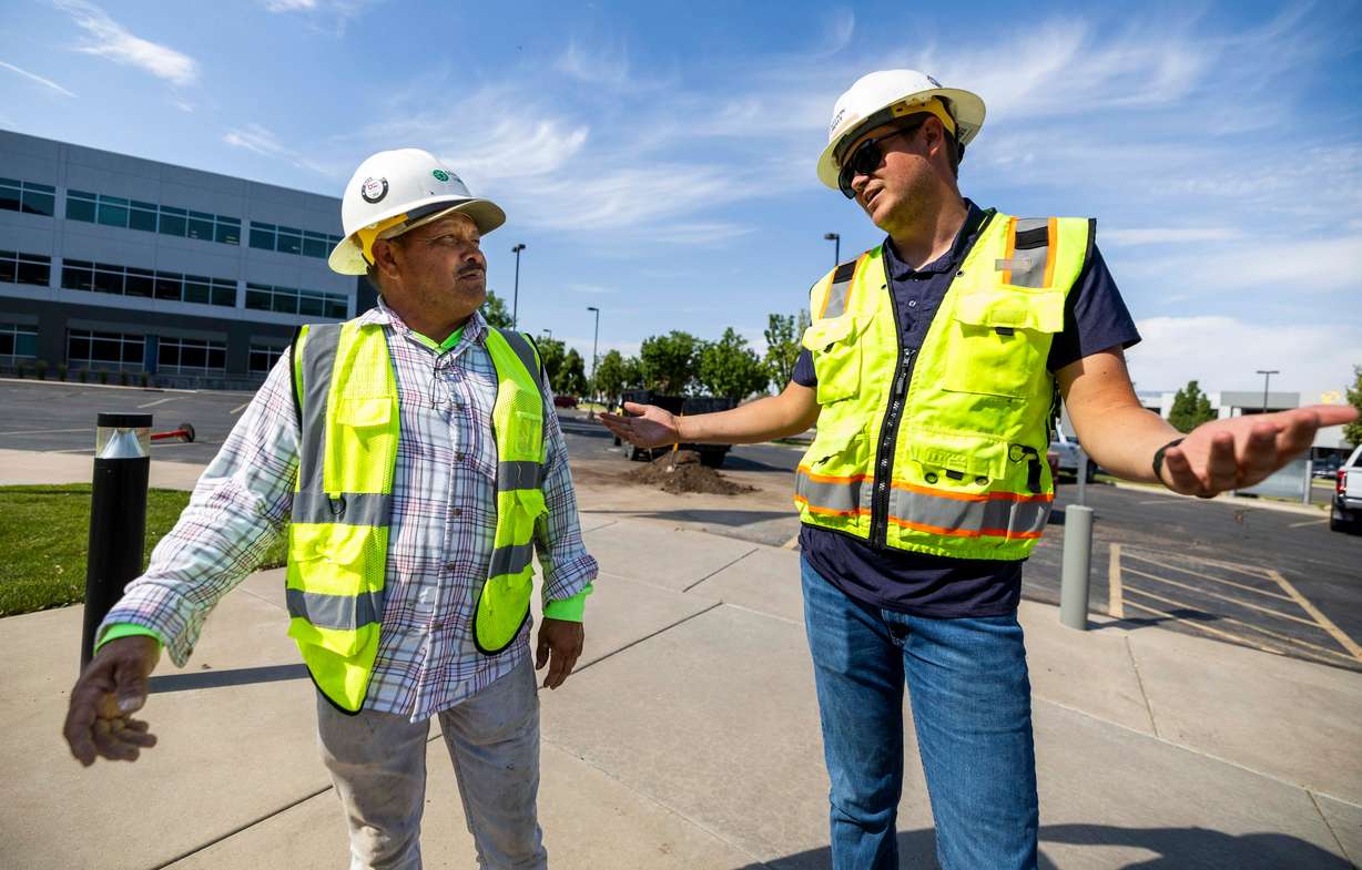 Juan Herrera, who has lived in the United States legally for the last 40 years, talks with Peter Stratton, vice president of operations at Stratton Landscape Group at a work site in Lindon on July 1. Herrera said while illegal immigration is a problem, deportations are not the answer.