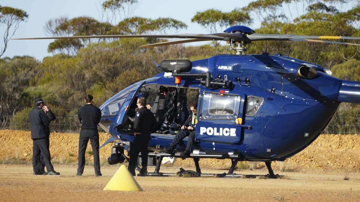 Police wait by a helicopter in Beacon, Western Australia, Friday, as they prepare to search for missing German backpacker Carolina Wilga. She was found alive 12 days after getting lost in the Australian Outback.