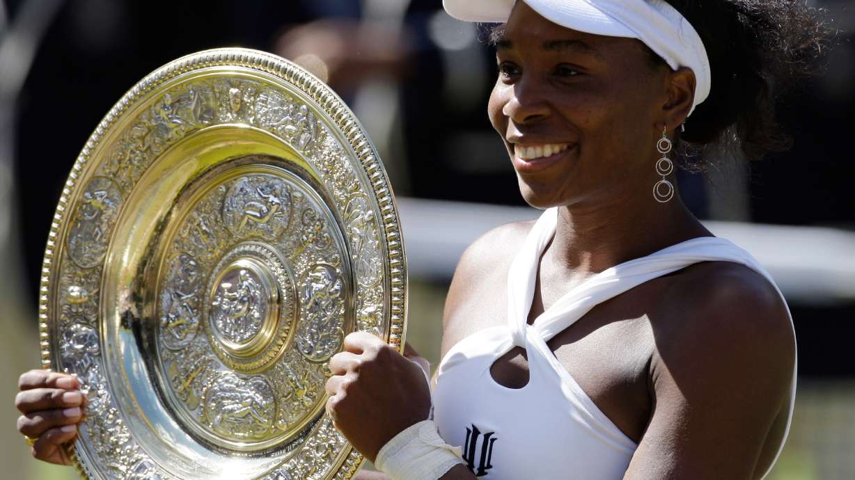 FILE - Venus Williams holds the trophy after defeating her sister Serena to win the Women's Singles Championship on the Centre Court at Wimbledon, Saturday, July 5, 2008.