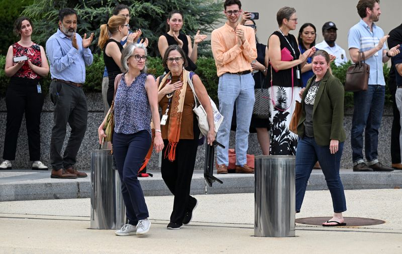 State Department workers as people clap during an impromptu sendoff event in Washington, Friday. Over 1,350 workers were fired as the Trump administration began an overhaul of its diplomatic corps.