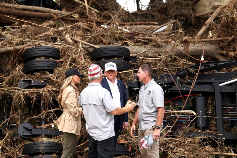 President Donald Trump and first lady Melania Trump speak with first responders in Kerr County, Texas, Friday. Trump said recent spending cuts did not relate to the disaster response's effectiveness.