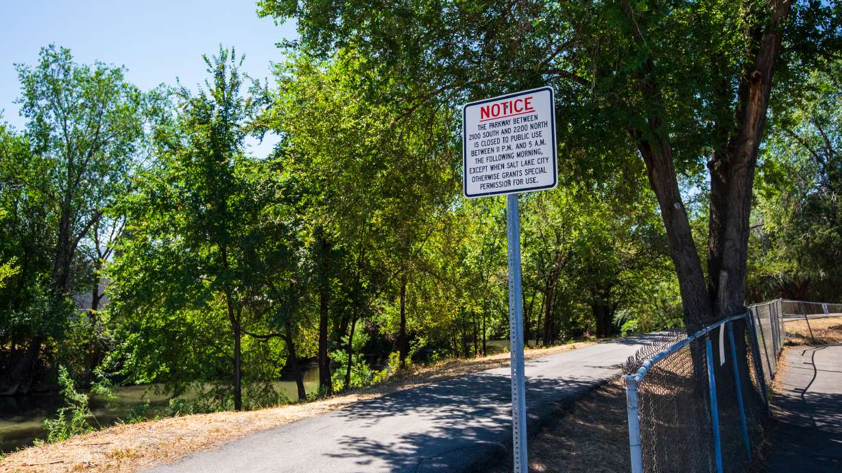 A sign warning of Jordan River Parkway trail closure hours near 500 North in Salt Lake City on July 11. Nearly 100 arrests were made during a multiagency sweep of the trail between August and late November, state officials said on Thursday.