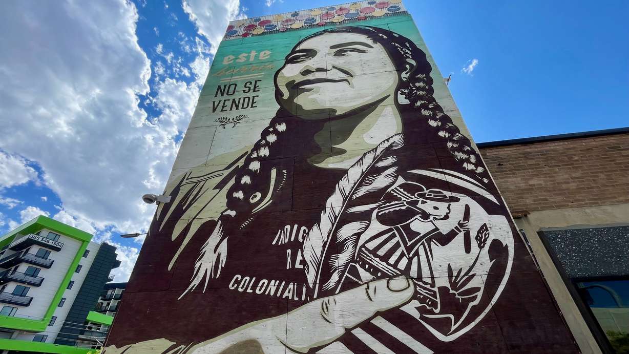 A mural located on North Temple east of El Asadero in Salt Lake City with a message reading, in English, "This neighborhood isn't for sale," underscoring the gentrification pressures in the area. The mural is by Jessica Sabogal.
