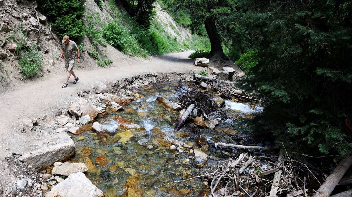 Cyle Buxton walks on an eroded portion of the road that leads to his property in Big Cottonwood Canyon’s Cardiff Canyon in Salt Lake County on Wednesday.