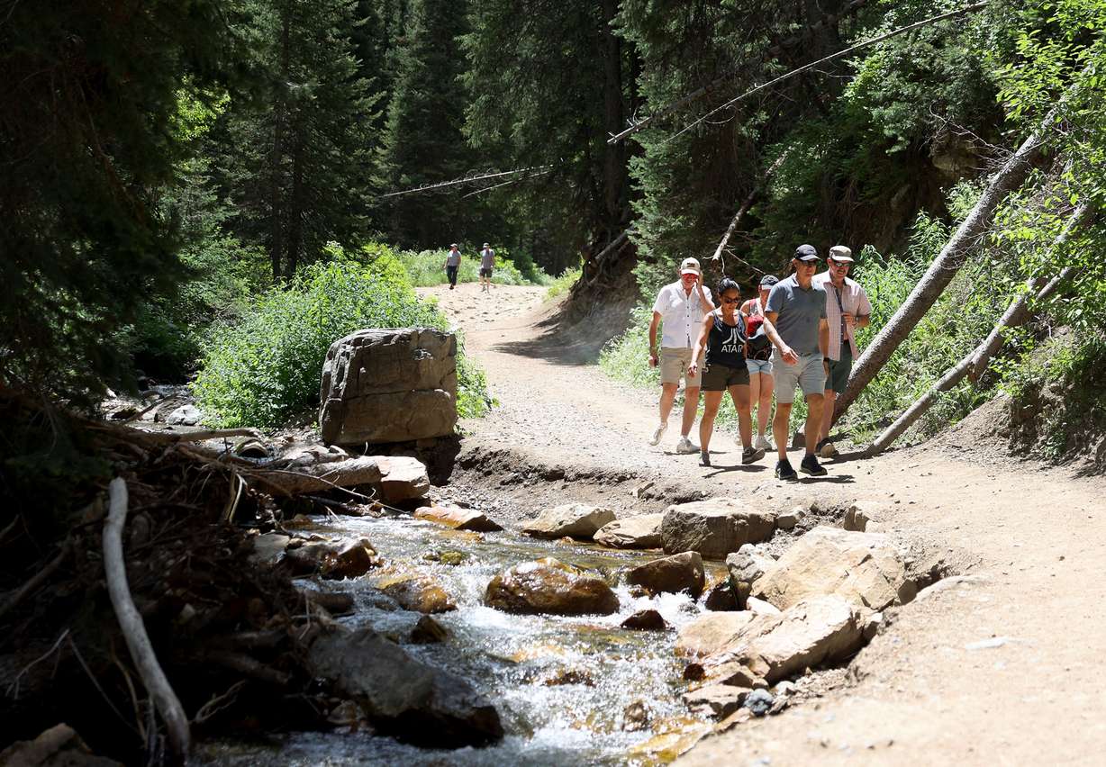 Hikers walk near an eroded portion of the road that leads to Donut Falls and private property in Big Cottonwood Canyon’s Cardiff Canyon in Salt Lake County on Wednesday.