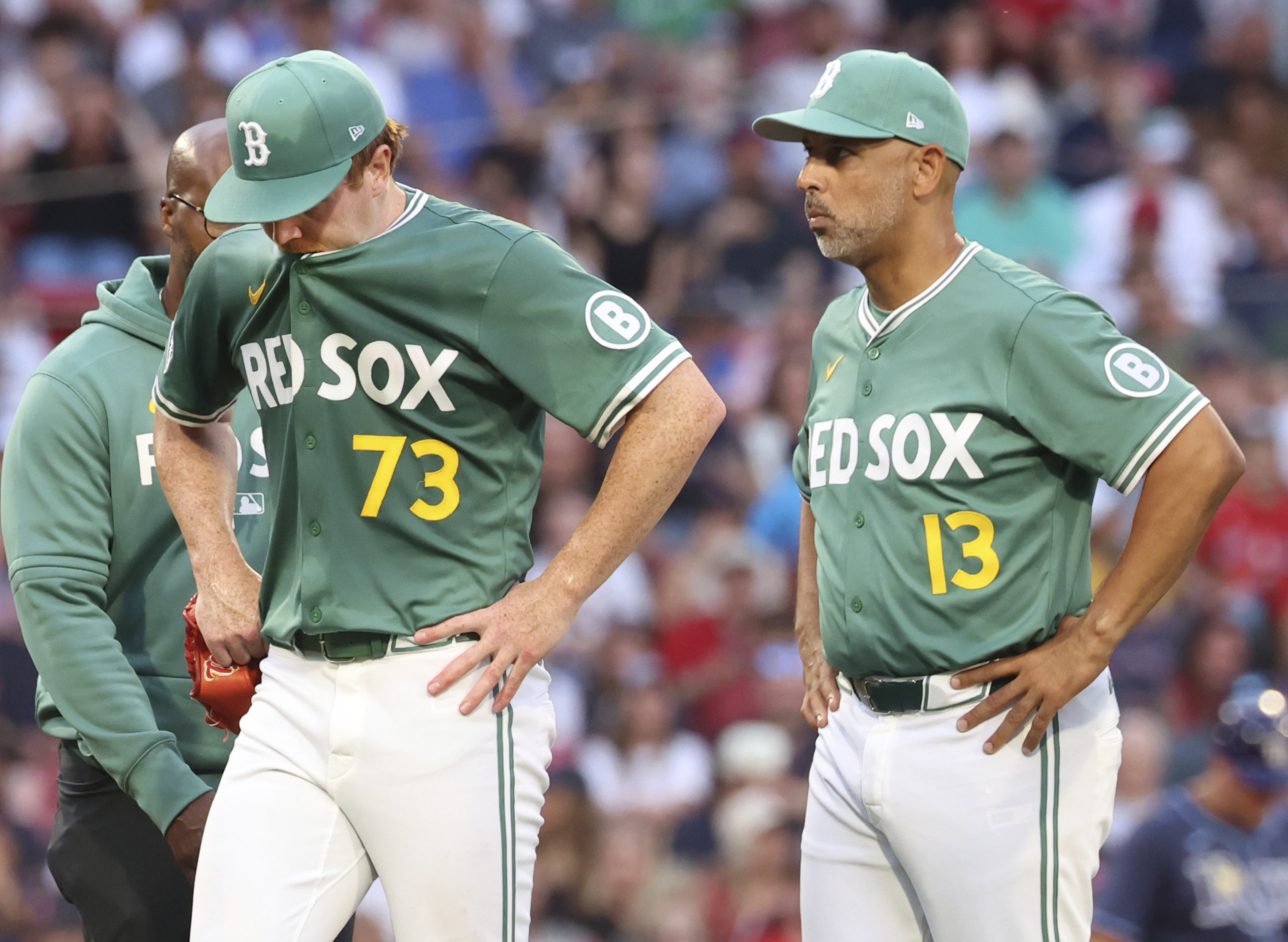 Boston Red Sox pitcher Hunter Dobbins (73) walks off the mound next to manager Alex Cora (13) after an injury during the second inning of a baseball game against the Tampa Bay Rays, Friday, July 11, 2025, in Boston.