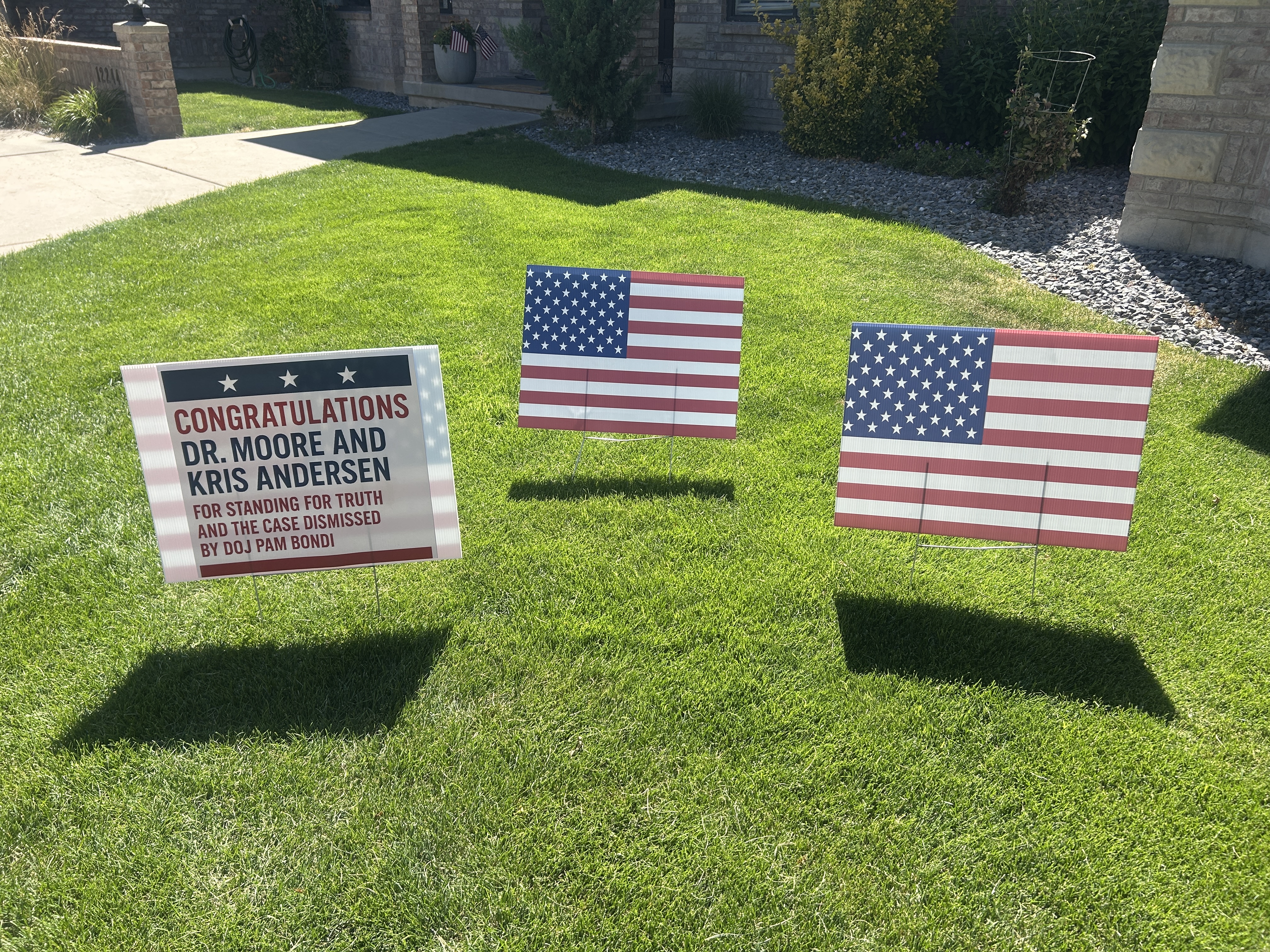 Signs outside a house are posted to celebrate federal charges against Utah plastic surgeon Michael Kirk Moore being dropped on Saturday. Moore was accused of distributing fake COVID-19 vaccination cards to people who did not want to get a vaccination but needed a card.