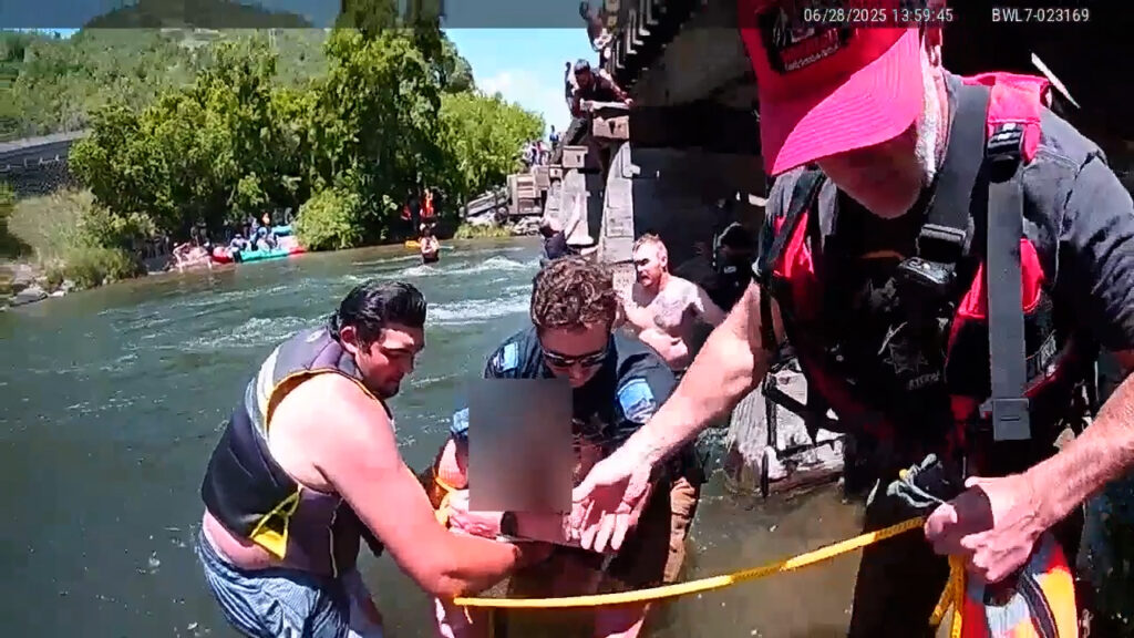 Tiffinie Wolf is pulled to safety by Utah Ranger Wyatt Manis and others on the Provo River, June 28.