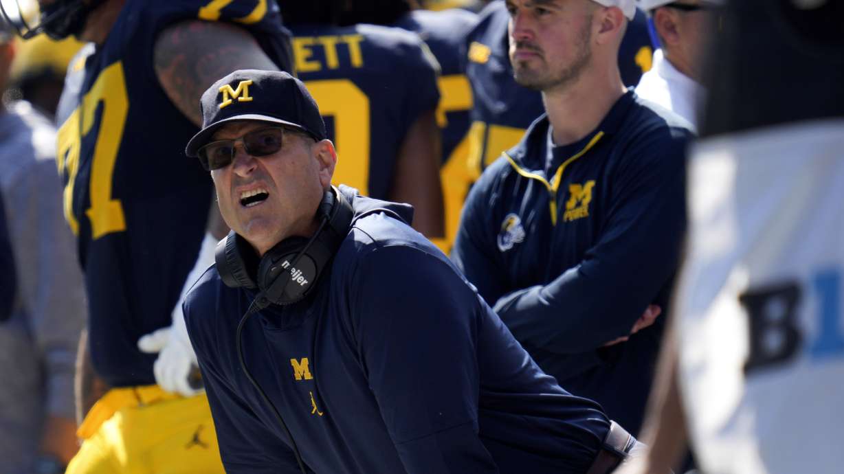 FILE - Michigan head coach Jim Harbaugh, front left, watches against Rutgers as analytics assistant Connor Stalions, right, looks on during an NCAA college football game in Ann Arbor, Mich., Sept. 23, 2023.