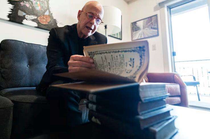Amos Guiora flips through a book that was taken by Nazis from his Jewish grandfather during World War II as Guiora is interviewed by a Deseret News reporter at his home in Salt Lake City on Feb. 24. The books were taken from his paternal grandfather, Shlomo Natan Goldberg, when he arrived in Auschwitz, and he later died there on May 26, 1944. The books were recently returned to Guiora by an organization in Germany.