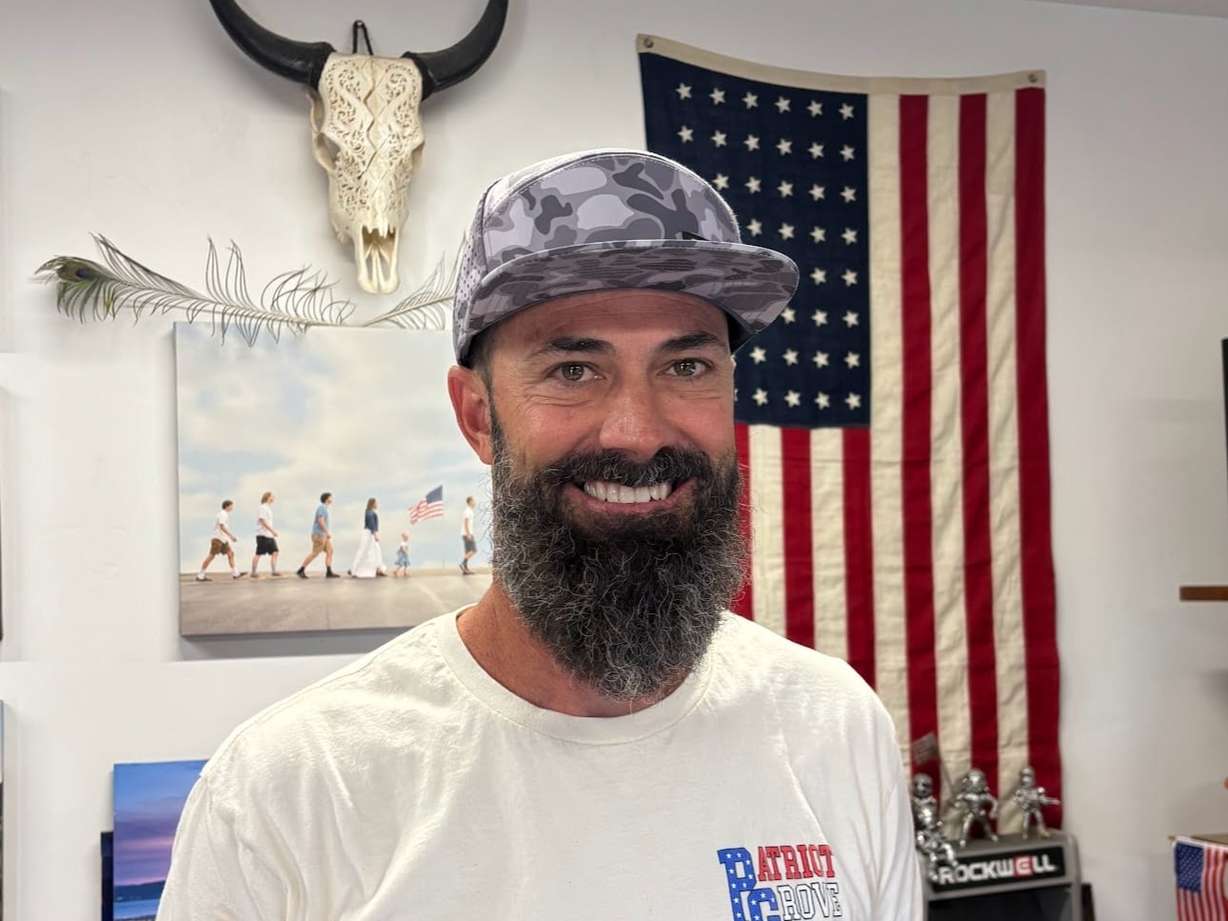Kyle Fox stands in front of an American flag. Fox flies "the world's biggest American flag" every summer at Grove Creek Park in his hometown of Pleasant Grove.