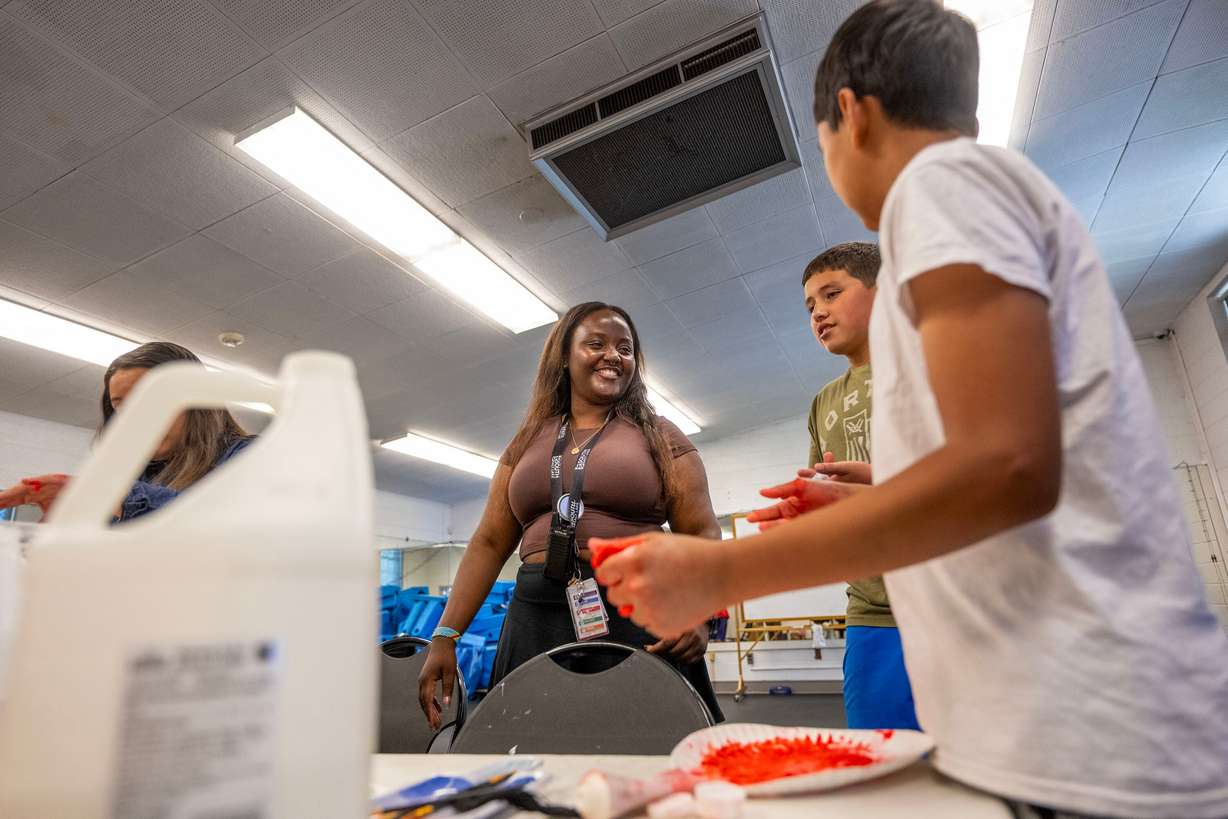 Counselor Zaina Kashama laughs with Felipe and Aman as they make slime during summer activities assisted by counselors at Central Park Community Center in South Salt Lake City on Monday.