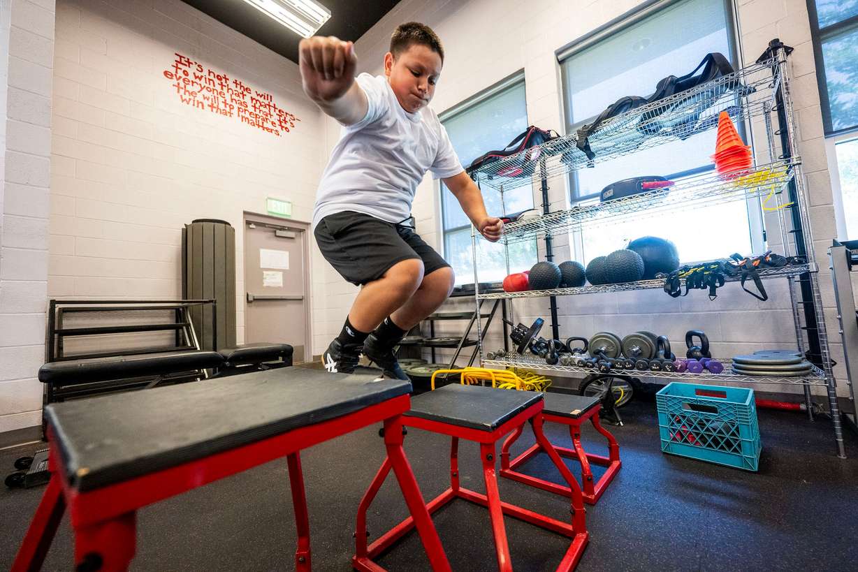 Randy jumps onto a stand as he works out in the gym, as he and other kids take part in summer activities assisted by counselors at Central Park Community Center in South Salt Lake City on Monday.