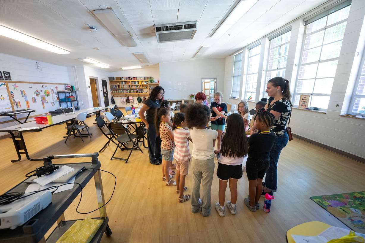 A group of girls and counselors circle up at the end of their time together as they take part in summer activities assisted by counselors at Central Park Community Center in South Salt Lake City on Monday.