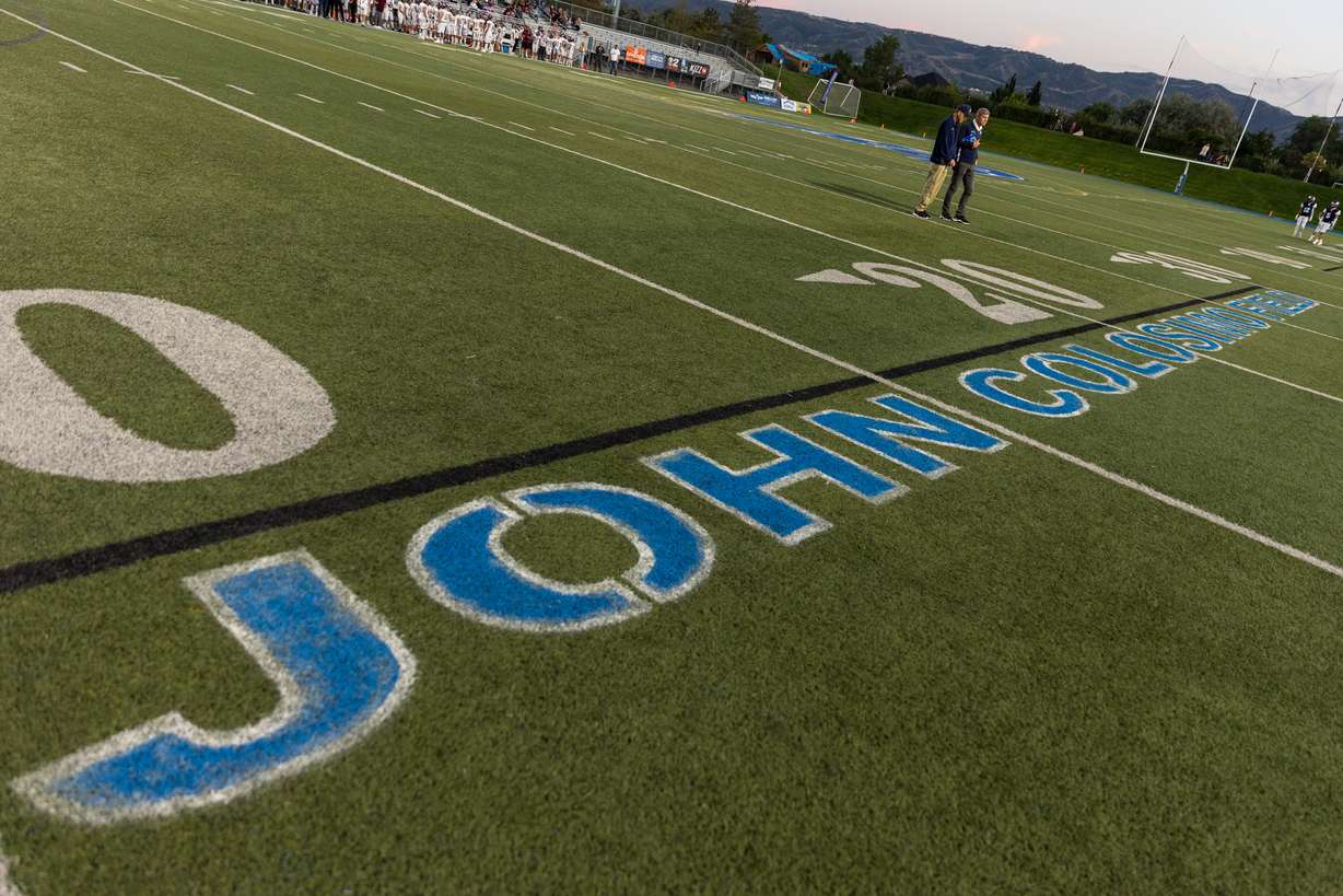 Juan Diego principal Galey Colosimo, right, stands next to his big brother, John Colosimo, on the field during a ceremony recognizing John Colosimo by naming the field after him in Draper on Friday, Sept. 16, 2022.