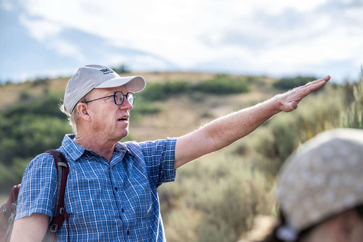 BYU researcher Phil Allen points out areas of native plants and weeds as he and students Cora Hatch and Isabella Pullan hike the Indian Road Trail near the mouth of Provo Canyon to collect seeds on Tuesday. Allen has found that wildflowers help stop the spread of wildfires.
