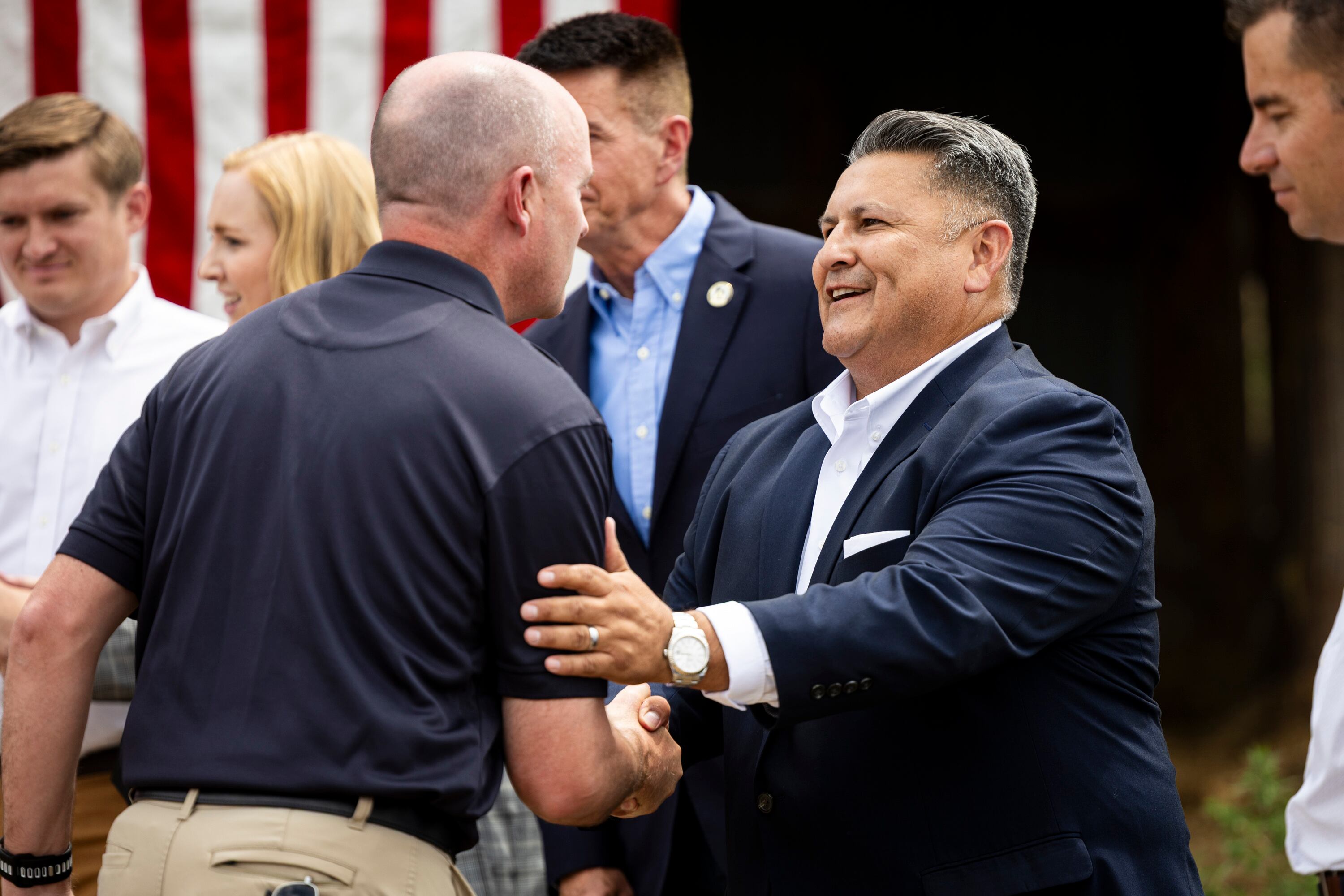Cooper Wimmer, executive vice president at Strider Technologies, right, shakes hands with Utah Gov. Spencer Cox after a press conference at a farm in Palmyra on Tuesday, about efforts to safeguard Utah’s land, liberty and strategic interests from foreign influence.