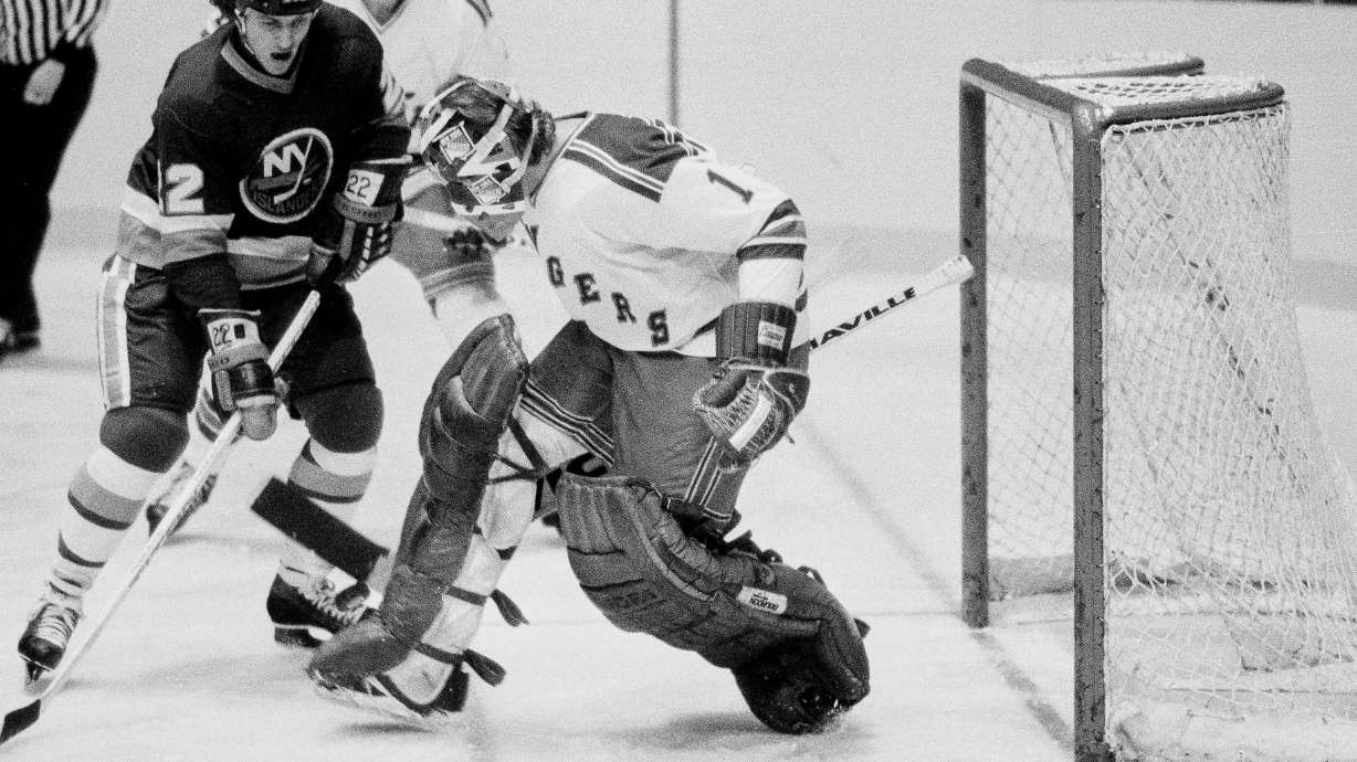 FILE - New York Islanders' Mike Bossy, left, watches the puck about to be deflected by New York Rangers goalie Wayne Thomas during an NHL hockey game at New York's Madison Square Garden, Nov. 12, 1978.