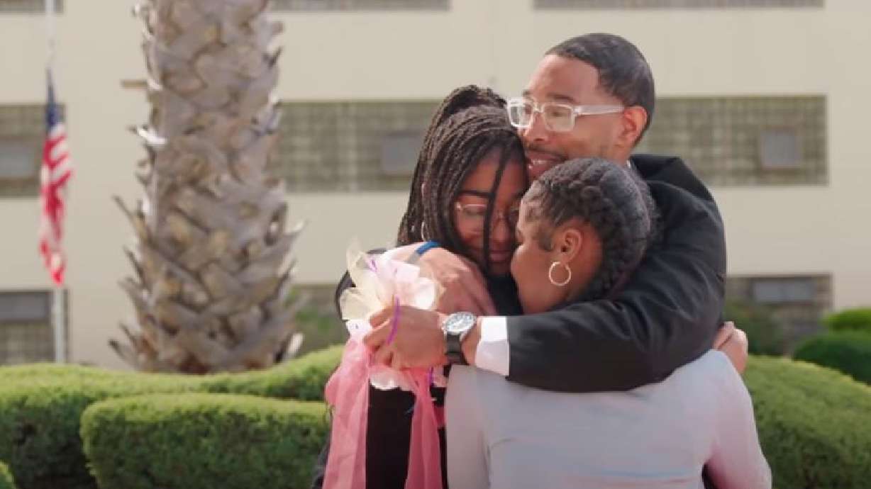 A father who is incarcerated at San Quentin Rehabilitation Center in San Quentin, California, hugs his daughters as they meet for a special daddy-daughter dance.