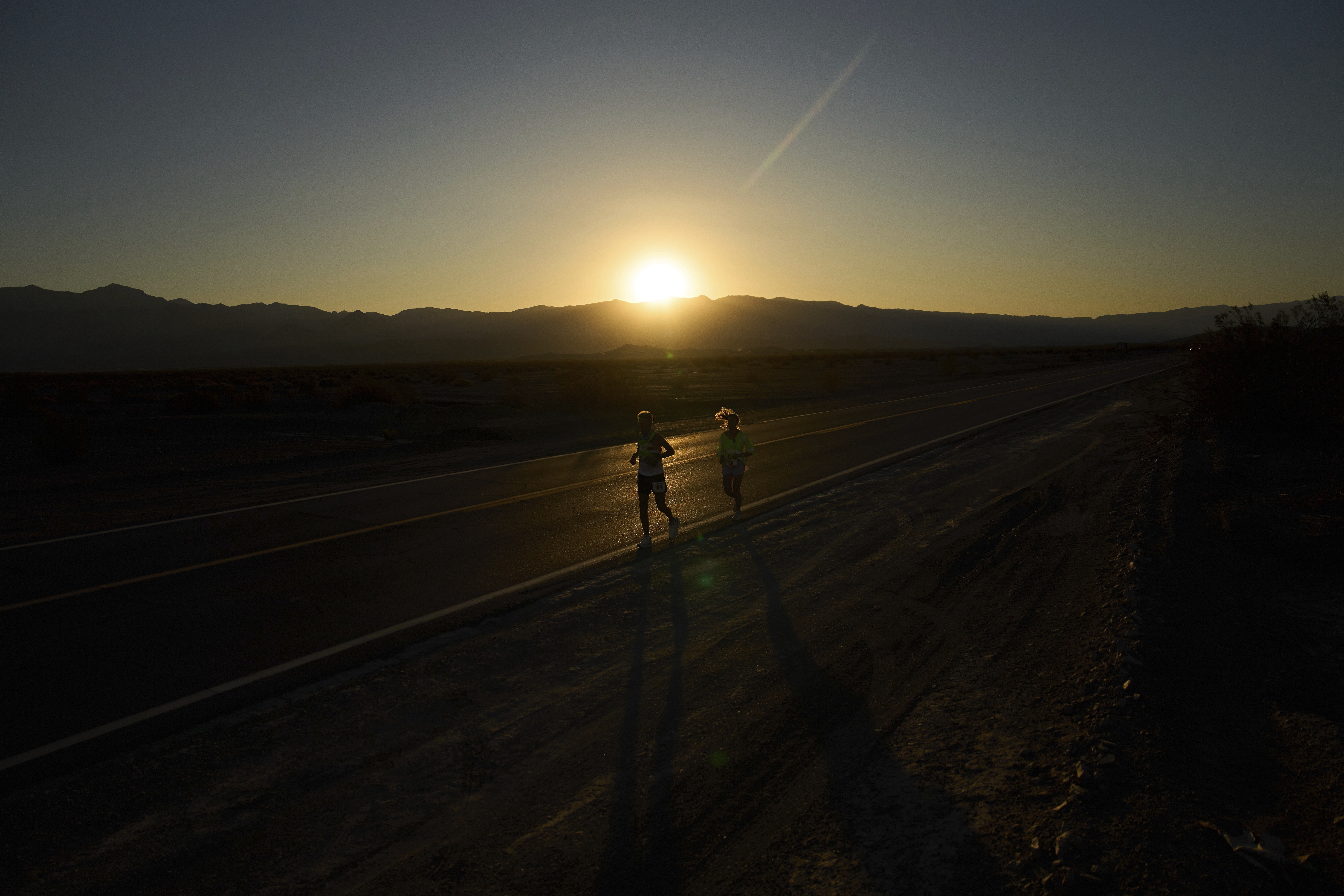 Danny Westergaard, left, runs with pacing help from daughter Madison Westergaard as the sun rises during the Badwater 135 Ultramarathon, Tuesday, July 8, 2025, in Death Valley National Park, Calif.