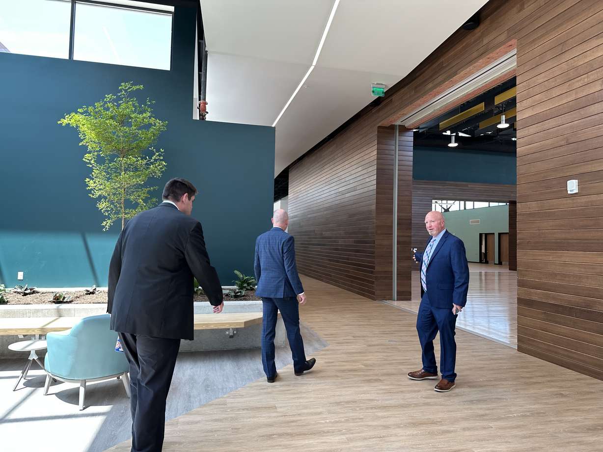 Utah State Developmental Center resident Patrick Horrigan and superintendent Tim Mathews give Gov. Spencer Cox a tour of the new comprehensive therapy building at the Utah State Developmental Center in American Fork on Thursday.