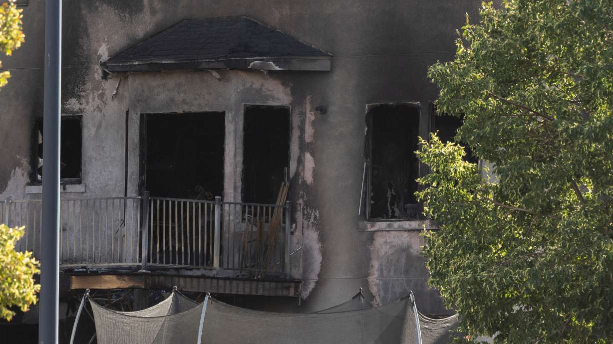 The back of a home is seen charred after it caught fire in West Jordan on Friday. A father who died along with another adult and two children in the house fire was responsible for causing it, police announced Tuesday.